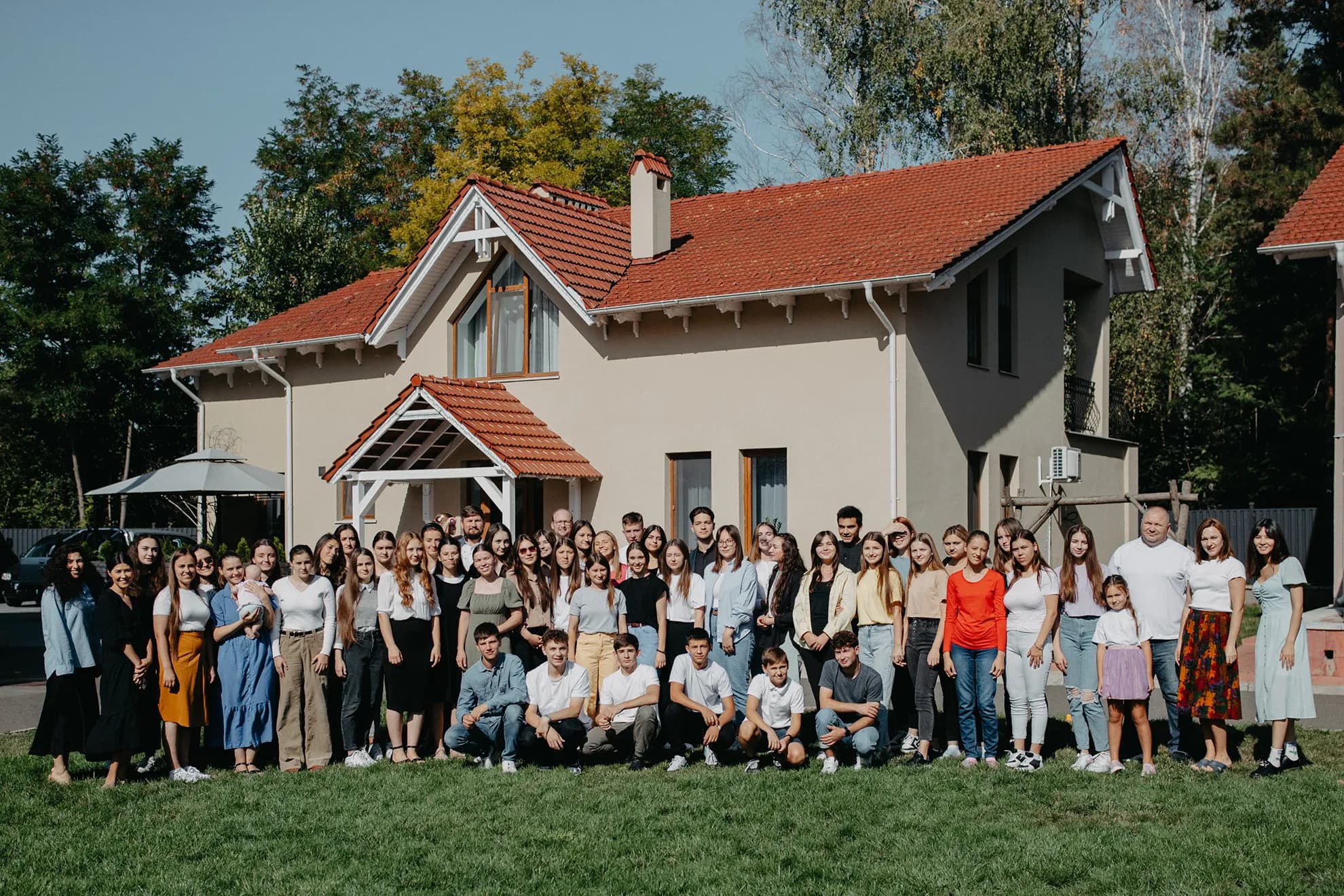 The teens and staff of The Orphan's Hands gathered outside a Vatra Village home