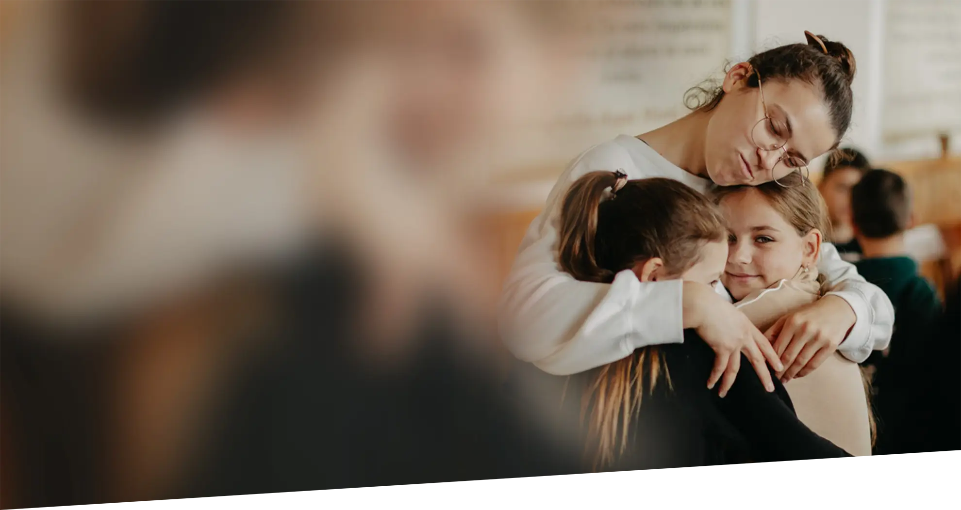 A house mother embracing two children at Vatra Village